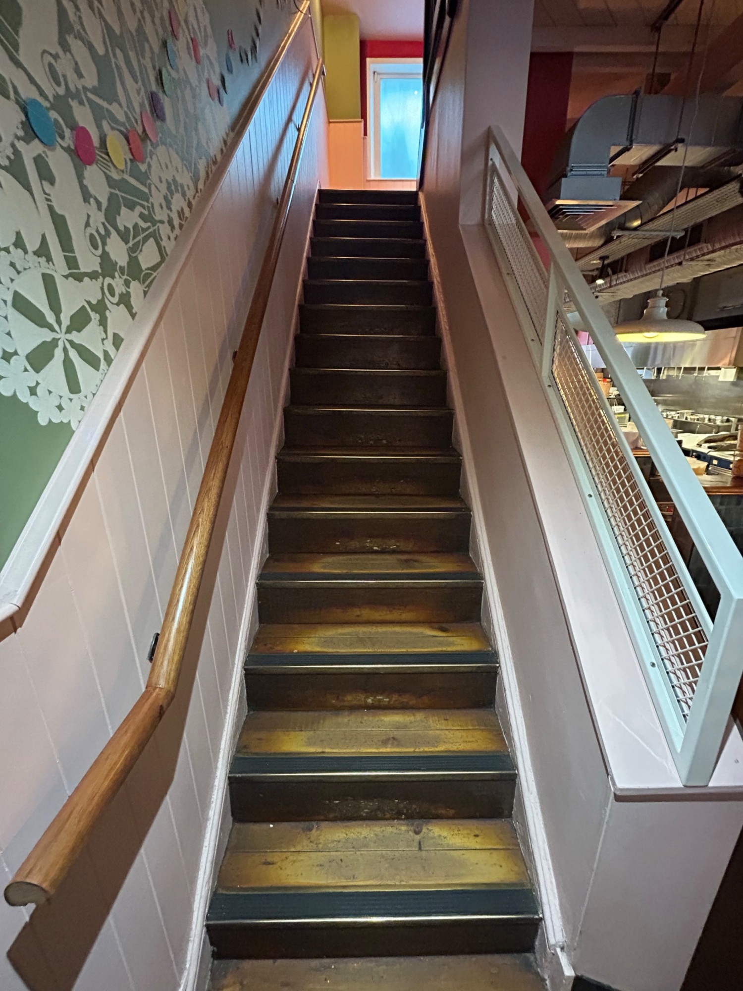 From first landing, facing right. Handrails along left and right. Second flight of stairs up ahead.