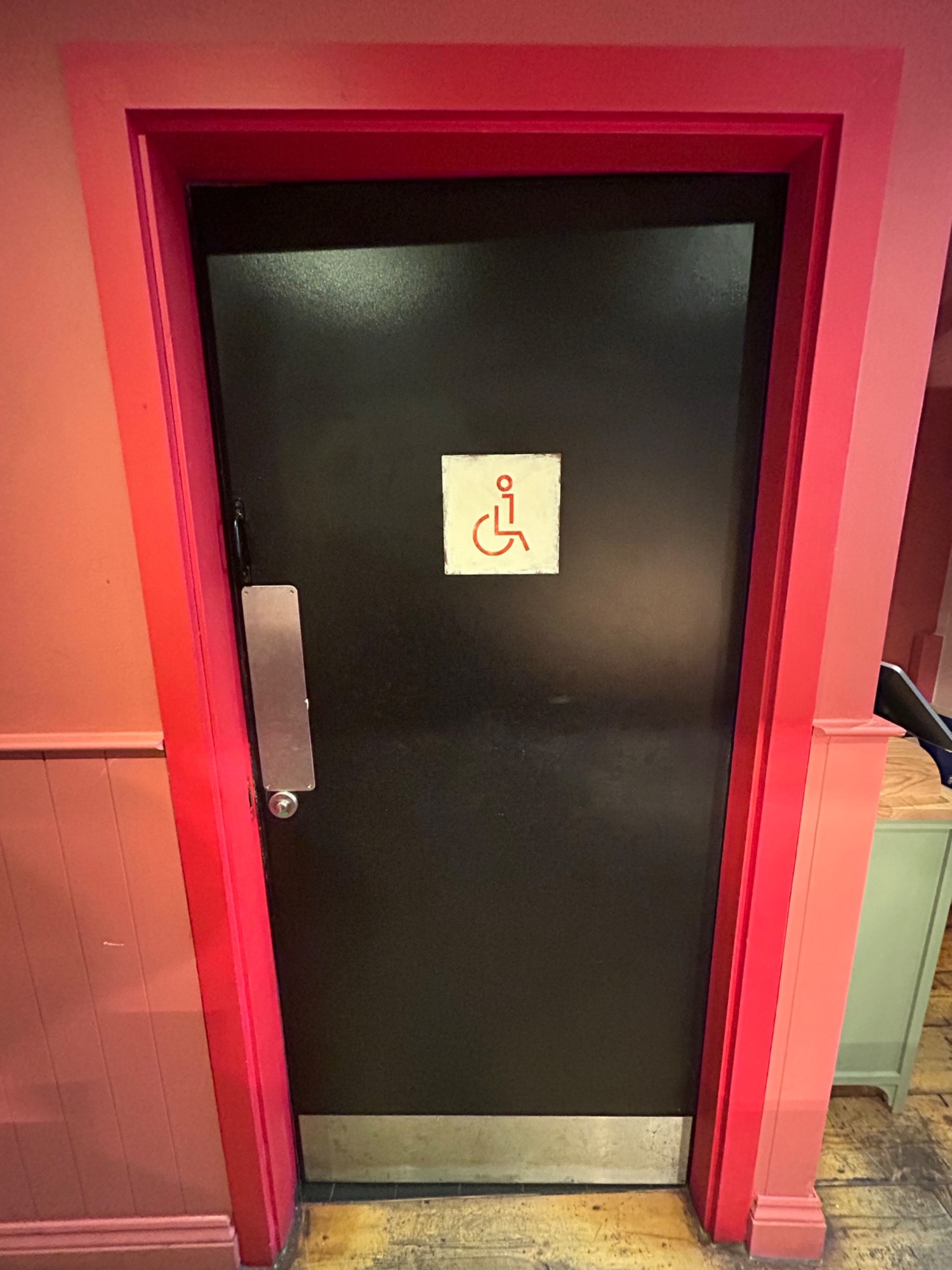 From middle of main area pathway, facing left. Single black wooden door. Push from left to open.
