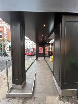 From right side of venue, facing left. Black open archway ahead. Built in ramp, then straight path to entrance on back right. Steps on back left.
