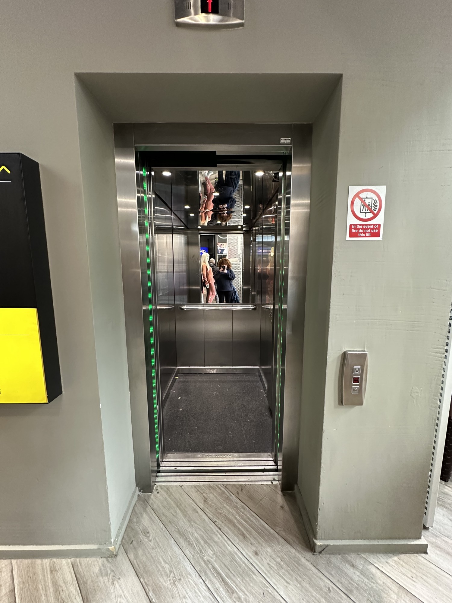 From right side of ground floor, looking into lift. Panel to call lift to the right of lift. Lift doors automatic opening from centre.