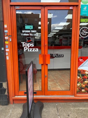 Double glass door, with orange doorframe. Handles at centre of door. Push to open. Sign obstructing entrance, in front of left door.