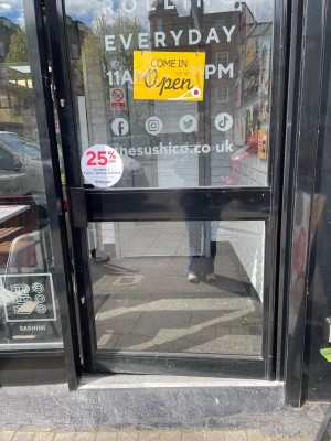 Single glass door with black frame. Push vertical handle on left to open.