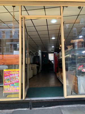 Glass door with gold metal frame. Push from gold metal handle on right side of door to open.
