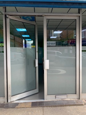 Glass doors with silver metal frames. Push from silver metal handles at center to open.