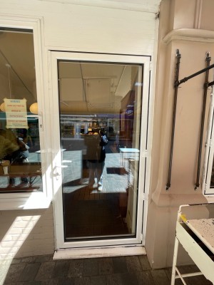 White glass door with handle at left, pull to open.