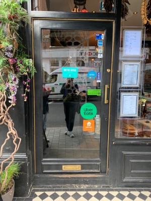 Black framed glass door ahead. Push golden handle on right to open.