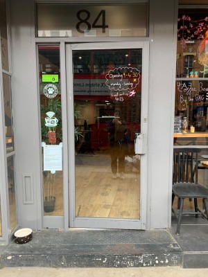 White framed glass door. Pull white metal handle from right to open.