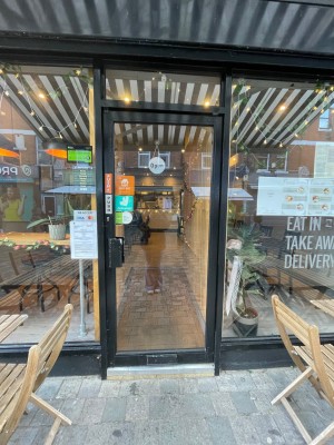 Black glass door with handle at left, push to open.