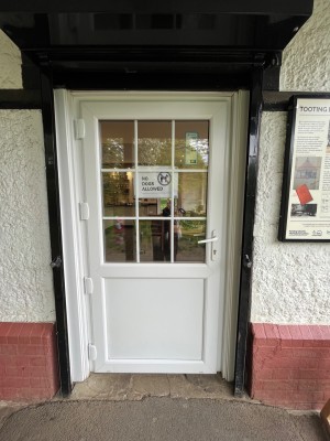 White door with glass panels. Pull open via handle on right.