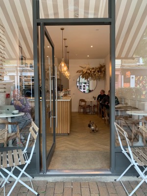 Grey metal framed glass door ahead. Push from silver metal handle on right of door to open.
