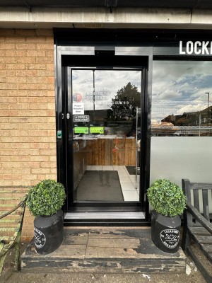 Single glass door with black doorframe ahead. Door slides open from left to right.