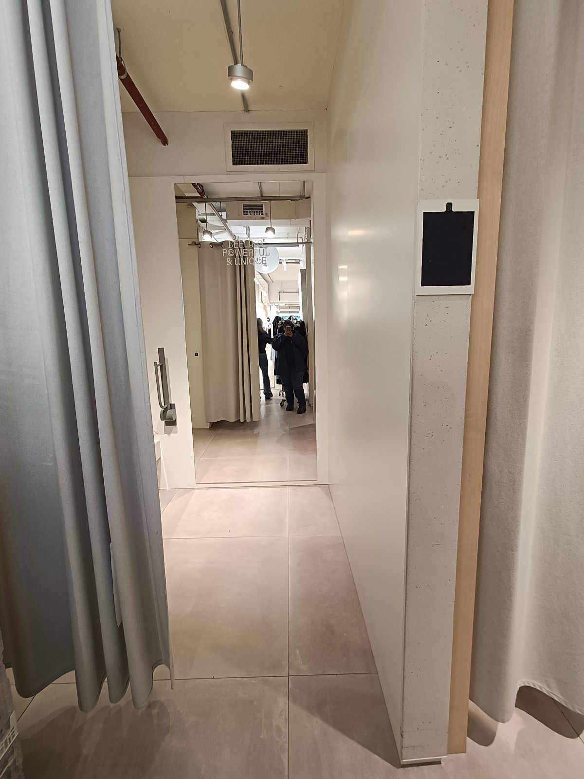 From in front of first fitting room, looking left. Curtain ahead.