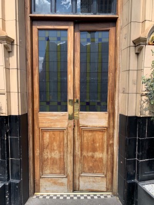 Double wooden and glass doors ahead. Push handles in centre to open.