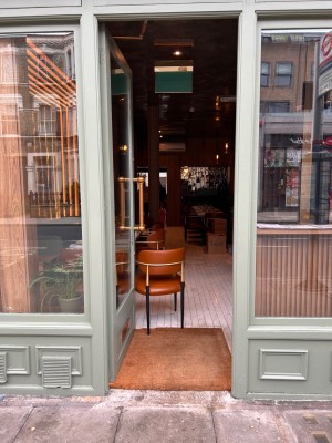 Door in centre of the venue , opens inwards from right with vertical gold handle.