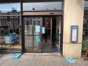 Glass door with brown metal frames ahead. Slide from right to left to open.