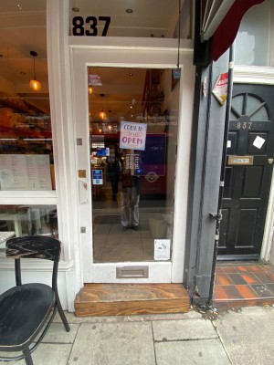 Glass door with wooden white frame ahead. Push from left to open.