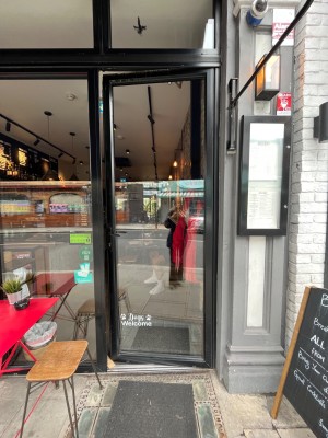 Glass door with black metal frames ahead. Push from left to open.