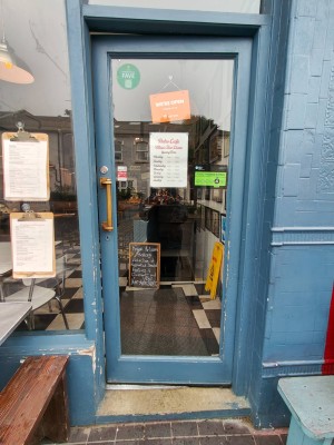 Blue framed single glass door. Push handle on left to open.