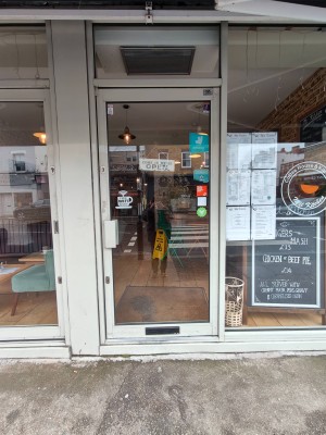 White framed single glass door. Push handle on left to open.