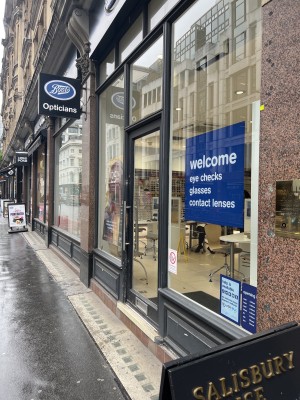Main entrance, raised step- no ramp. Glass door with a metal handle . Accessibility help available with an alternative entrance