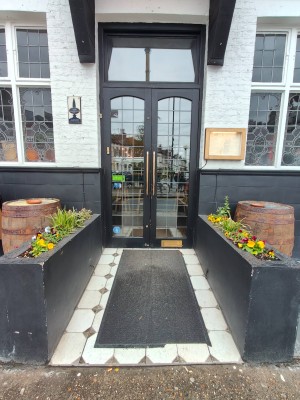 Black framed double glass doors. Pull handle on right of left door to open.