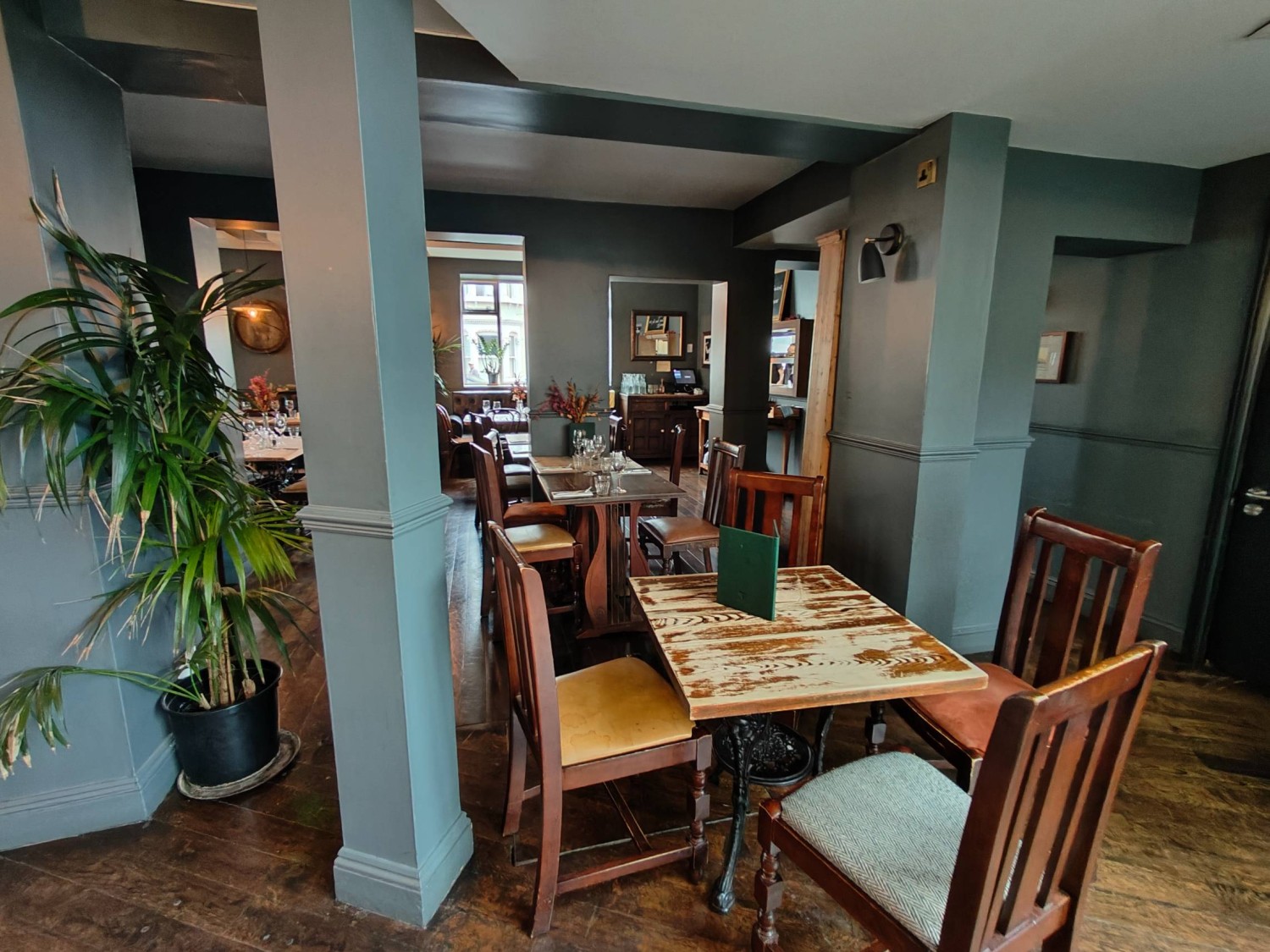 From end of path left of bar looking left. Pillar on left. Table and chairs along centre and back wall. Pillar on right.