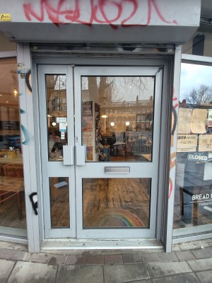 Grey framed glass doors ahead. Push grey handles in centre to open.