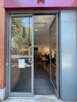 Double glass door with grey frame. Push vertical handle from middle to open.