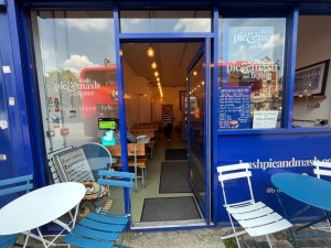 Single glass door with bright blue metal frame. Push blue metal handle from left to open.