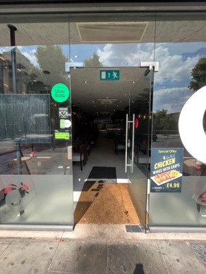 Single glass door. Long silver metal handle on left. Push to open.