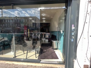 Single glass door. Silver metal handle push from left to open.