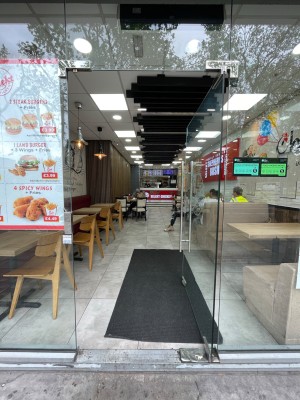 Single glass door with glass frame. Push vertical metal handle on left to open.