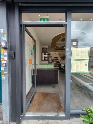 Grey framed door. Push silver handle on right to open.