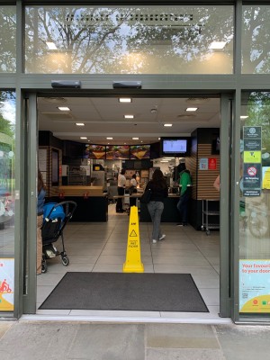 Glass doors with grey metal frame. Doors automatically slide from centre to open.