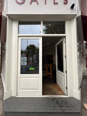 White and glass panelled doors with vertical silver handle to centre of right-hand door. Push to open.