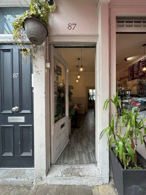 White and glass panelled door with silver handle to right of door. Push to open.