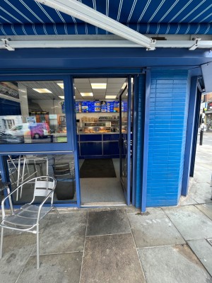 Single glass door in blue metal frame. Push blue metal handle from left to open.