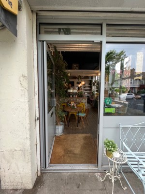 Single glass door with grey metal frame. Push grey metal handle from right to open.