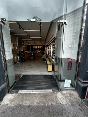 Double glass doors. Push silver metal handles from centre to open. Black wooden pillars either side.