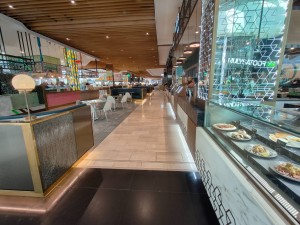 From right of venue facing left. No door ahead. Path in centre proceeds between food court seating on left and counter on right.
