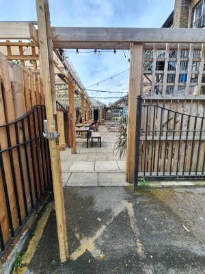 From parking area facing right. Wooden door. Pull handle on right to open.