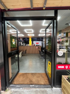 Double glass doors in black metal frame. Push black metal handles from centre to open.