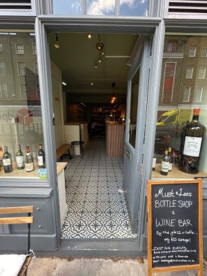 Grey glass door with handle at left, push to open.