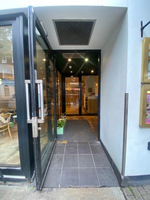 Glass door, with black doorframe. Silver handle on right. Pull to open.