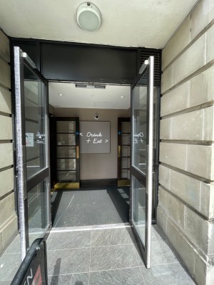 From street right of venue, facing venue. Glass double doors with handle in centre straight ahead. Pull to open.