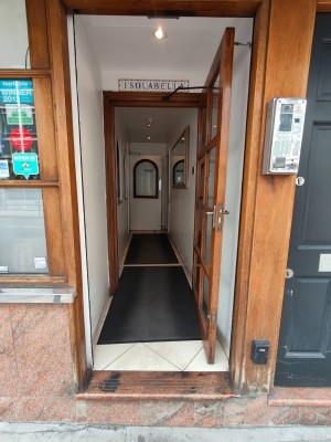 Glass and wooden door ahead. Pull handle on left to open.