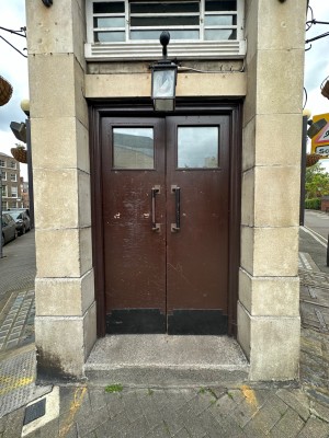 Brown and glass panelled doors with black handles in centre of doors. Push to open.