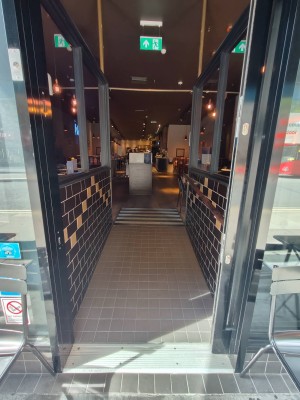 Glass door with metal frame ahead. Automatic door slides from left to right.