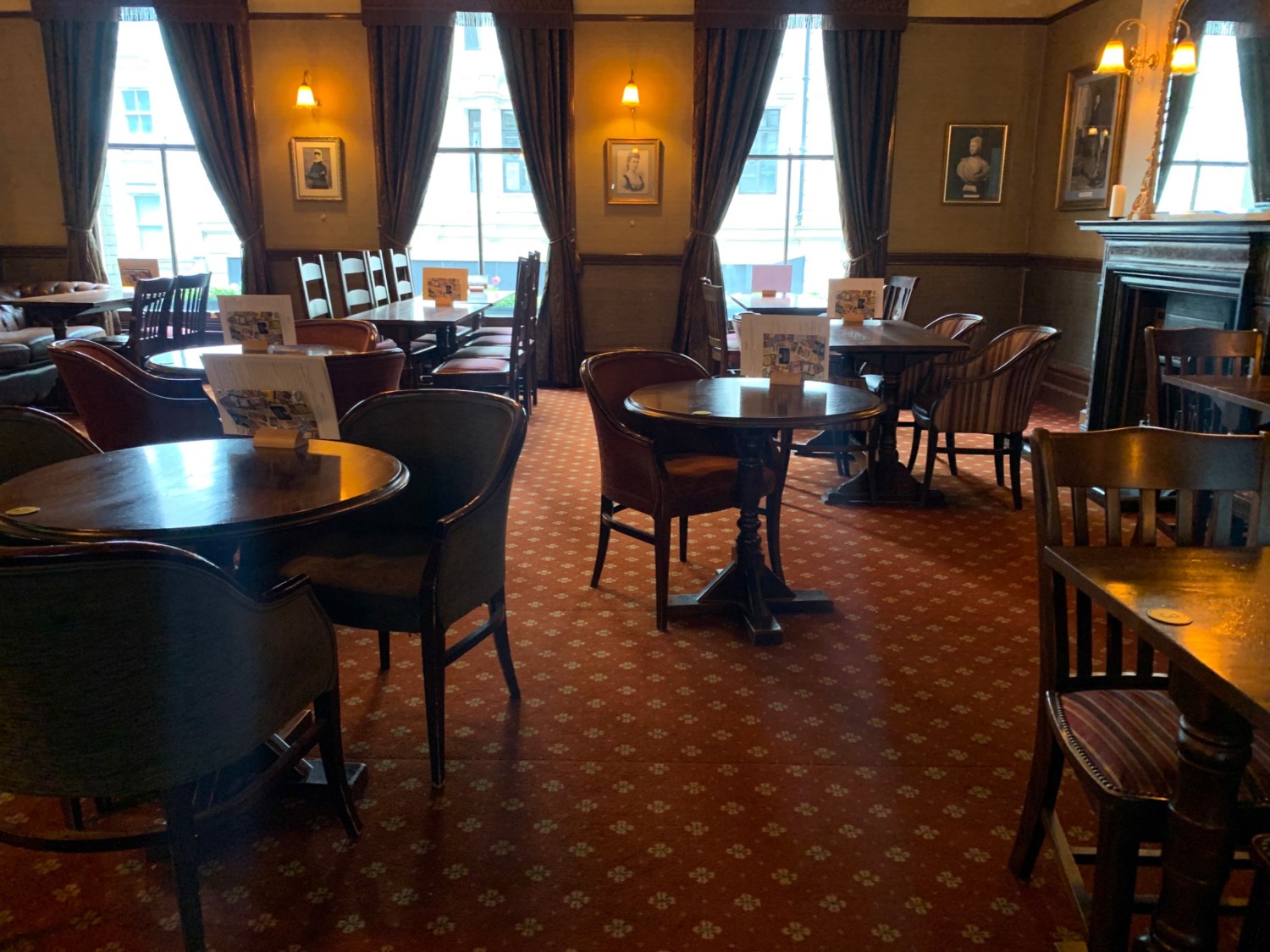 From end of counter, looking straight. Tables and chairs dispersed throughout room.