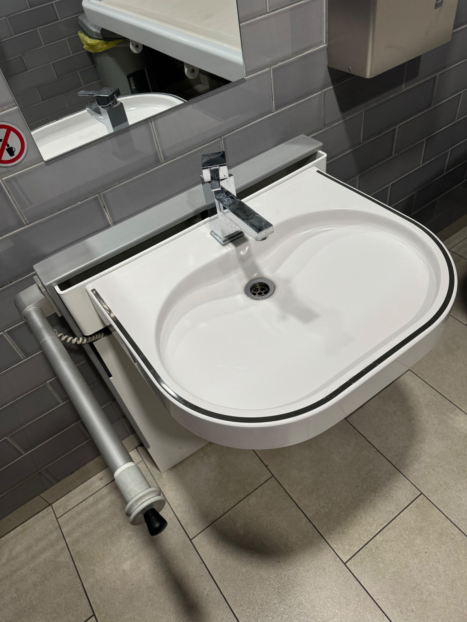 Height adjustable sink with hand dryer just behind it